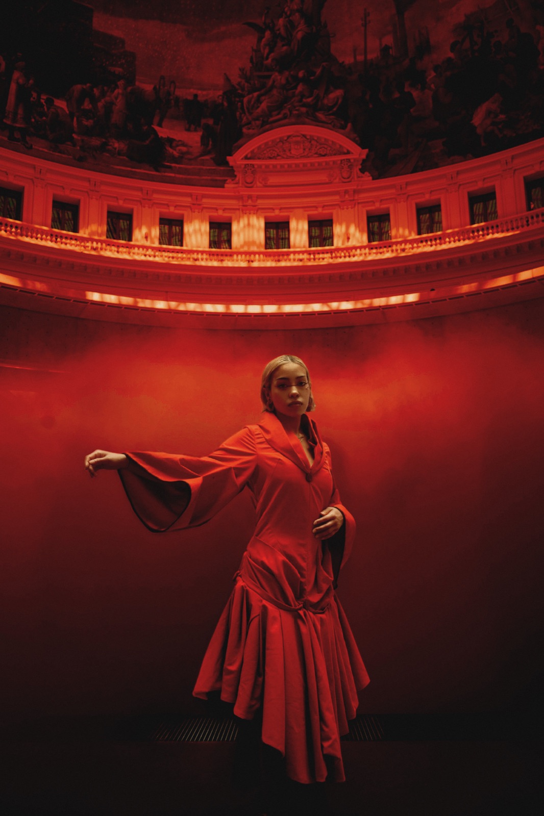 Ashalys, un bras tendu, dans la lumière rouge