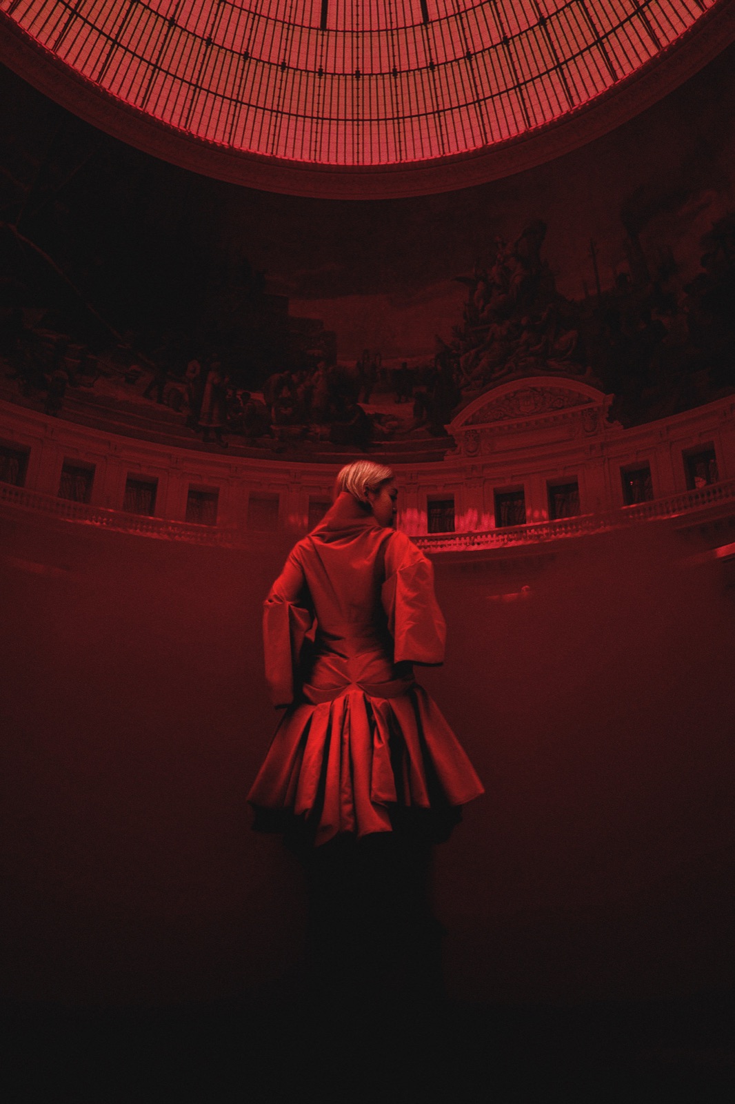 Ashalys de dos, sous une coupole baignée de rouge
